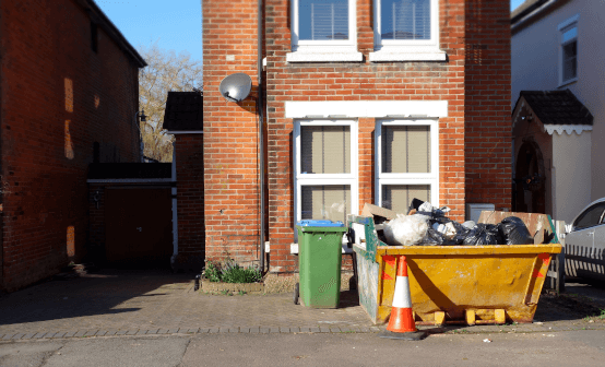 photograph of yellow skip outside a house